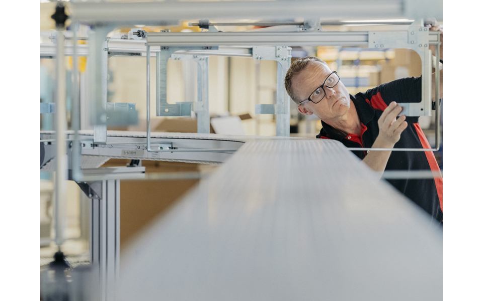 AMC engineer inspecting a custom-engineered aluminum conveyor frame during manufacturing process